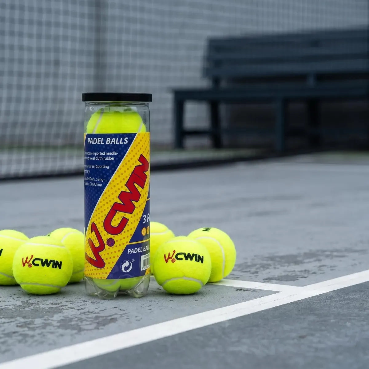 Tubo y pelotas de pádel CWIN sobre una cancha de pádel